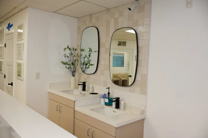 Berger Orthodontics dual brushing station with black mirrors and tile backsplash