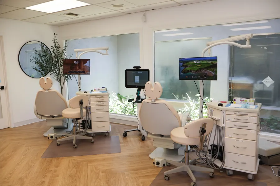 Berger Orthodontics open clinical bay with three chairs and olive tree